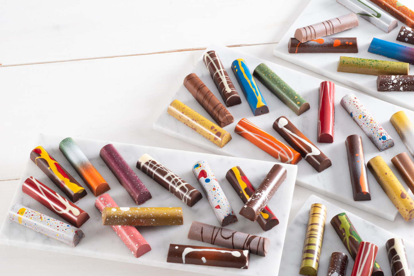 Assorted painted chocolate truffle bars on stone platters